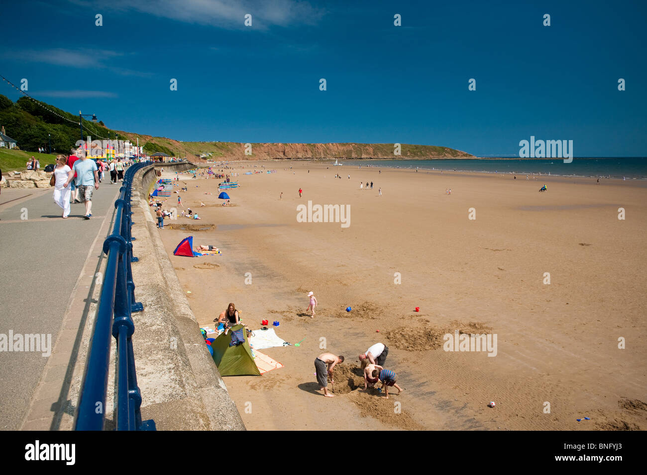 Badegäste, die die britischen Sommer am Strand im Ferienort Filey genießen die Sonne. Stockfoto