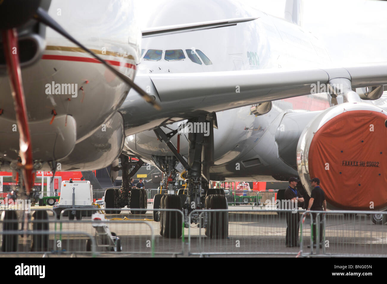 Sicherheitspersonal und statische Anzeige Flugzeuge aufgereihten auf der Farnborough Airshow der A380 auf der Rückseite und eine 777 vor. Stockfoto