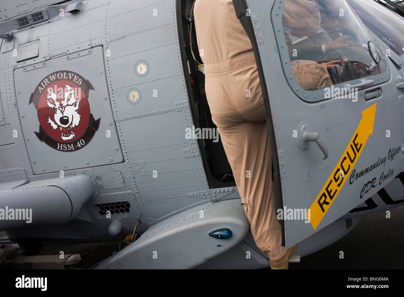 U.S. Navy Pilot zeigt Gäste um das Cockpit von Sikorsky MH-60R Hubschrauber auf der Farnborough Airshow. Stockfoto
