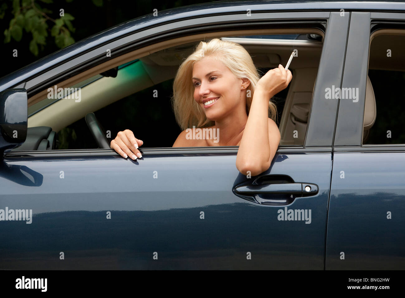 Frau, die raucht aus dem Fenster eines Autos Stockfoto
