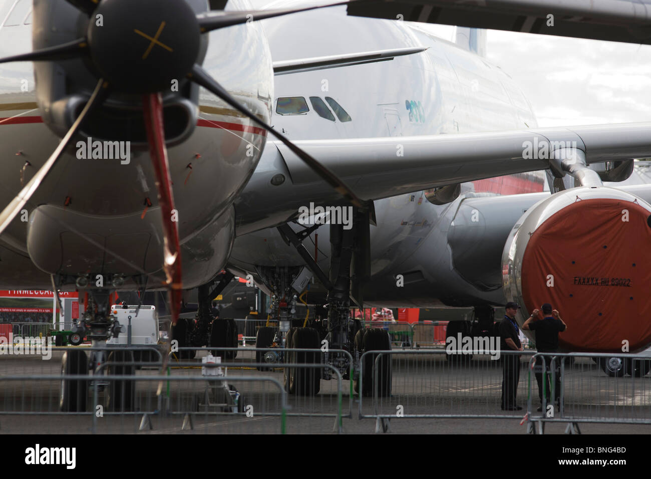 Sicherheitspersonal und statische Anzeige Flugzeuge aufgereihten auf der Farnborough Airshow der A380 auf der Rückseite und eine 777 vor. Stockfoto