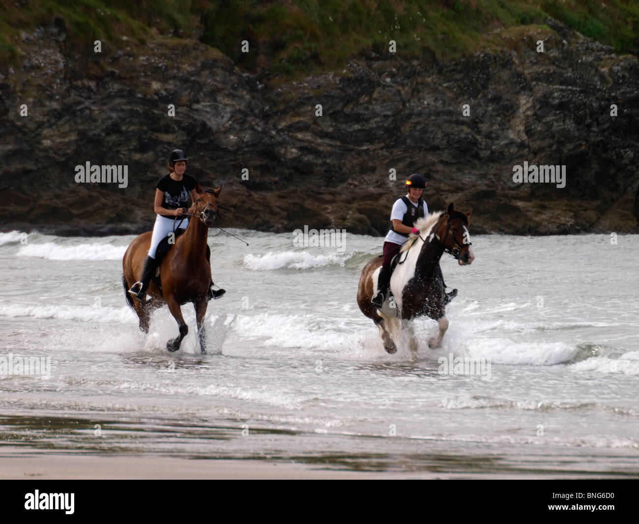 Reitpferde entlang der Strand, Par Sands, Cornwall, UK Stockfoto