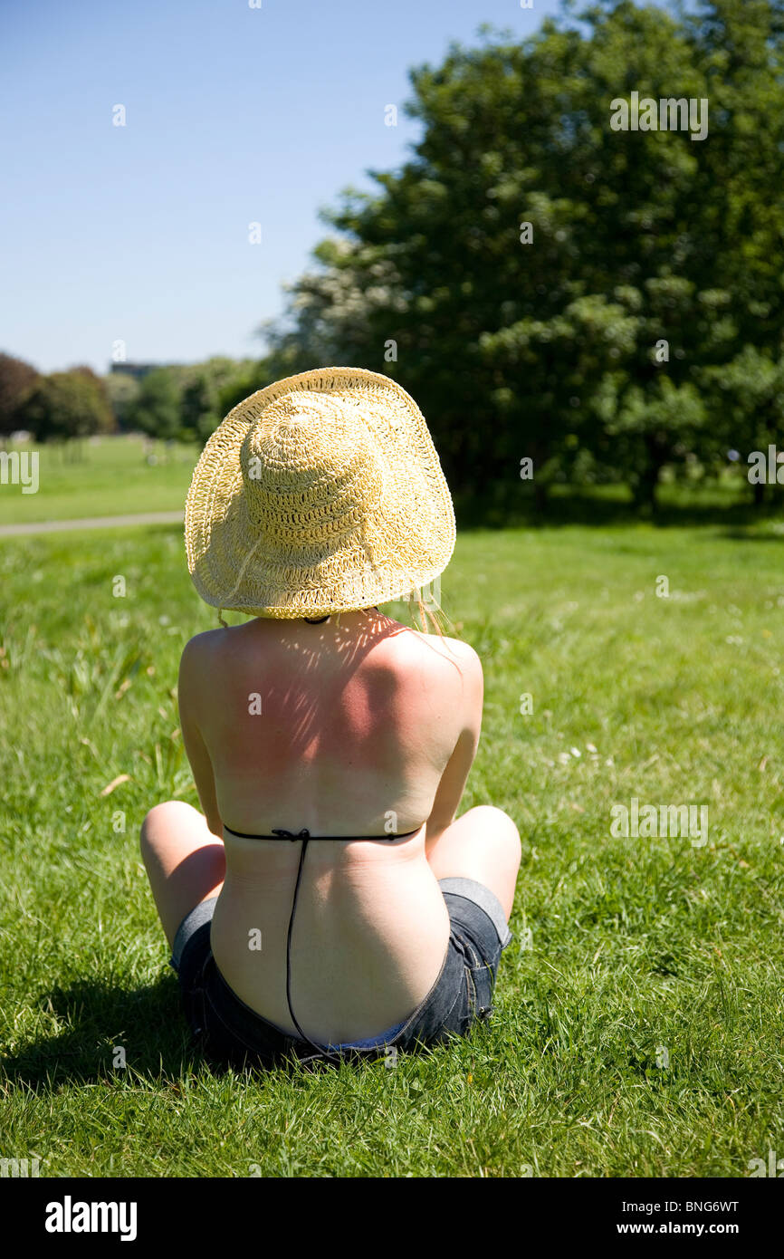 Sonne verbrannte Mädchen mit Strohhut im park Stockfoto