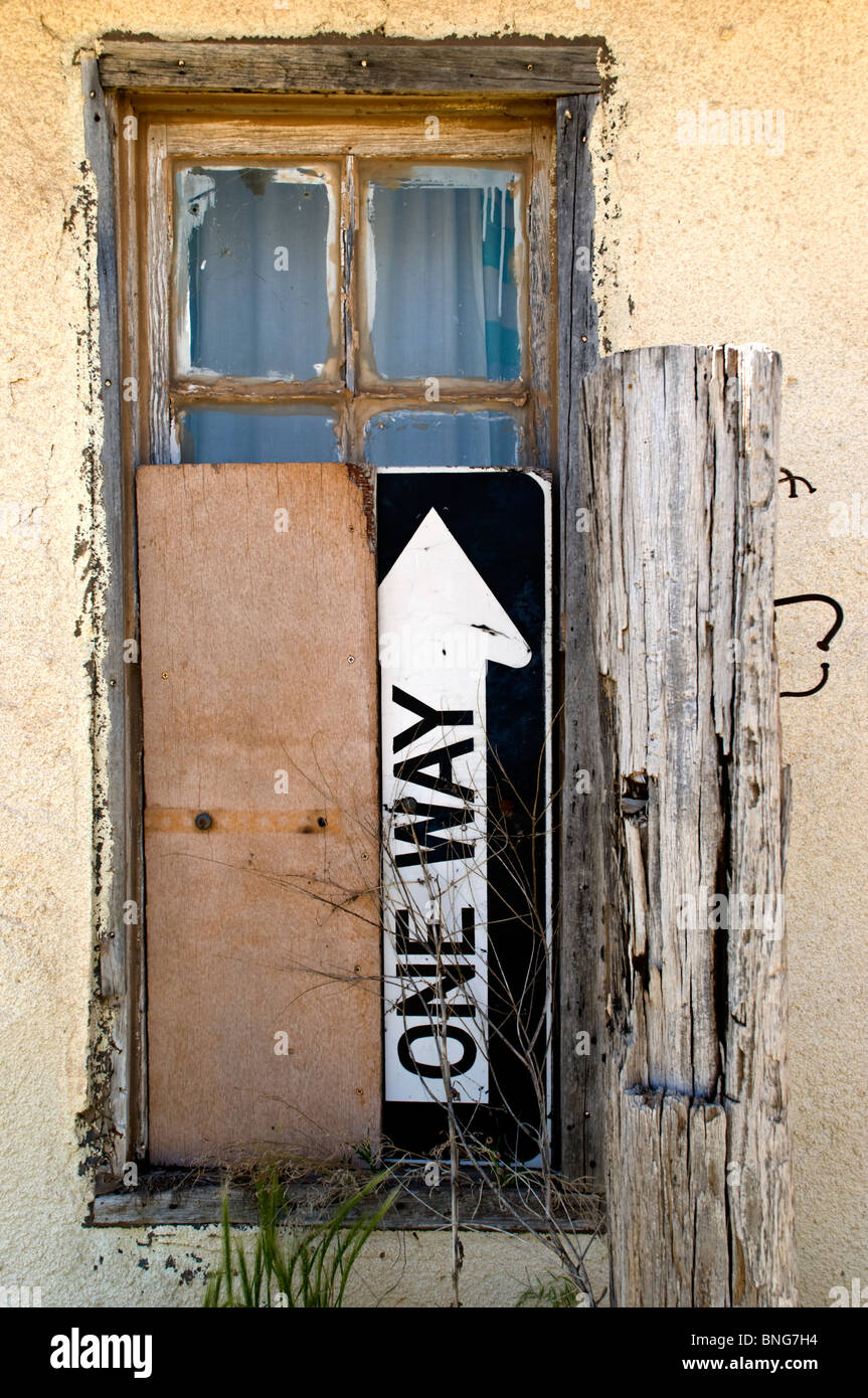 Übrig gebliebene Materialien und Verkehrszeichen werden verwendet, um verfallene Gebäude in Encino, New Mexico an Bord. Stockfoto