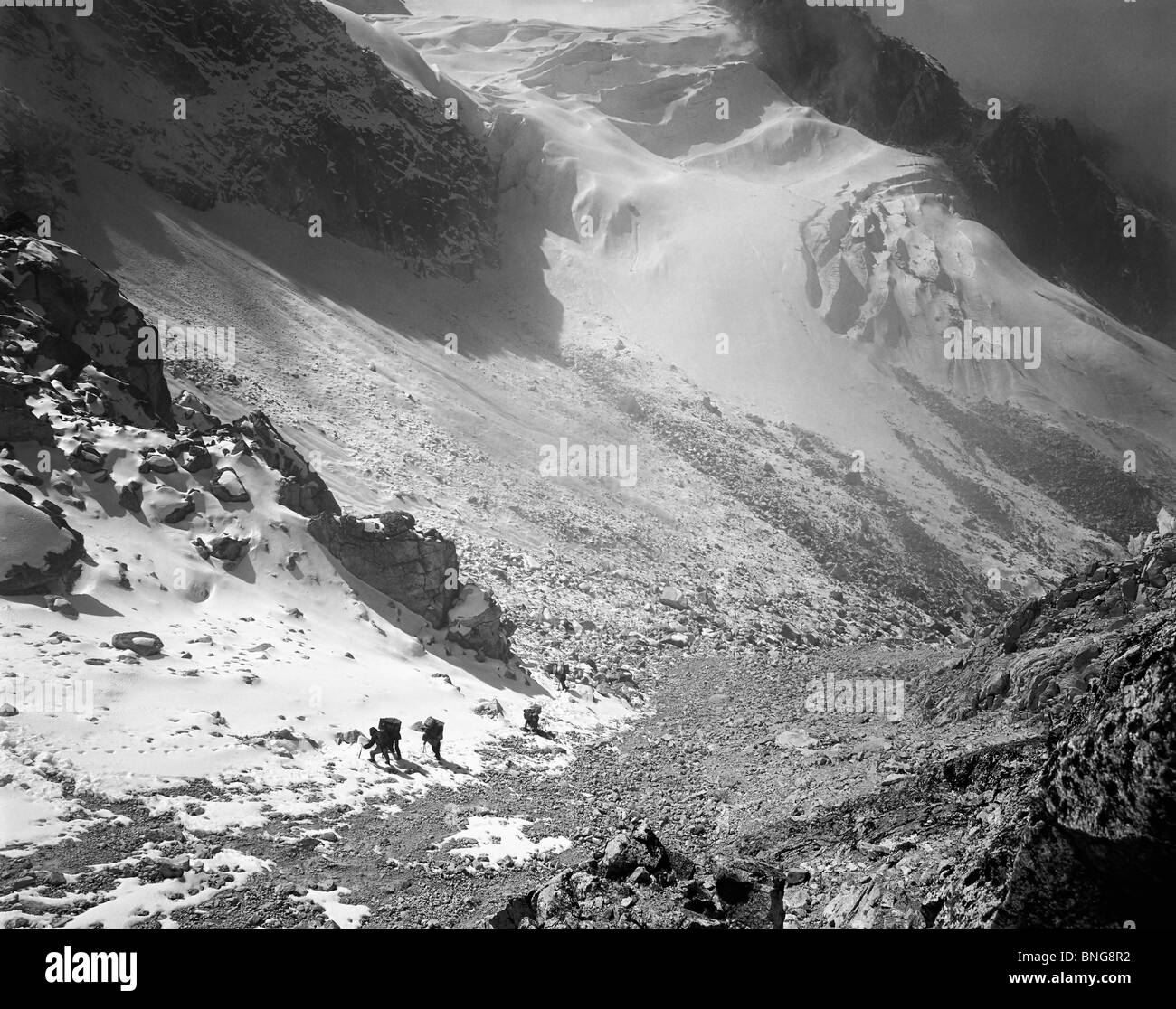 Porters kommen die letzten Hänge hinauf zum Pass im Lapsang-La mit Gletscher unterhalb der Kangchenjunga Region Osten Nepals Stockfoto