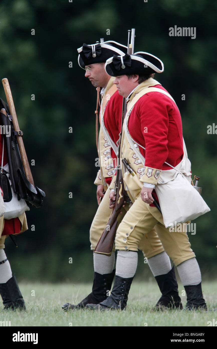 Rotröcke aus dem amerikanischen Unabhängigkeitskrieg 1775-1783. Brown Bess Musketen, Schnauze laden Steinschloss glatte Bohrungen Festival Geschichte 2010, Kelmarsh Hall, Northamptonshire. Re-Anactors erleben Sie britische Geschichte von den Römern bis zum zweiten Weltkrieg Stockfoto