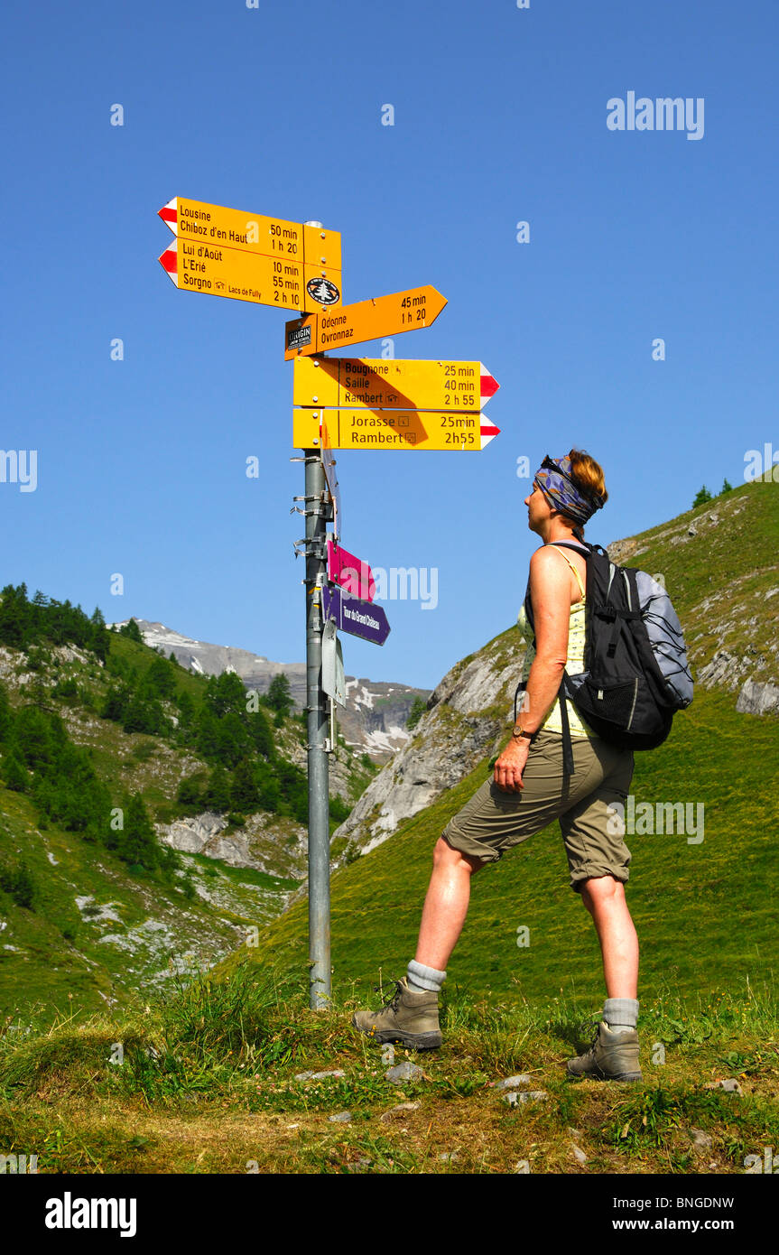Wanderer, lesen ein Richtungsanzeiger am Scheideweg auf der Alp Petit Pre im Wandergebiet von Ovronnaz, Wallis, Schweiz Stockfoto