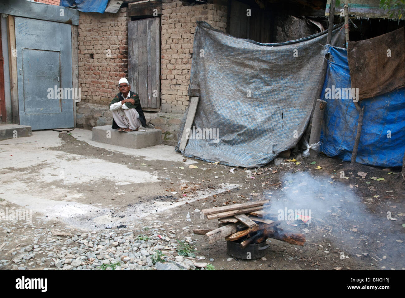 Ein Alter Mann sitzt vor seinem Haus in Srinagar, Jammu und Kaschmir, Indien. Stockfoto