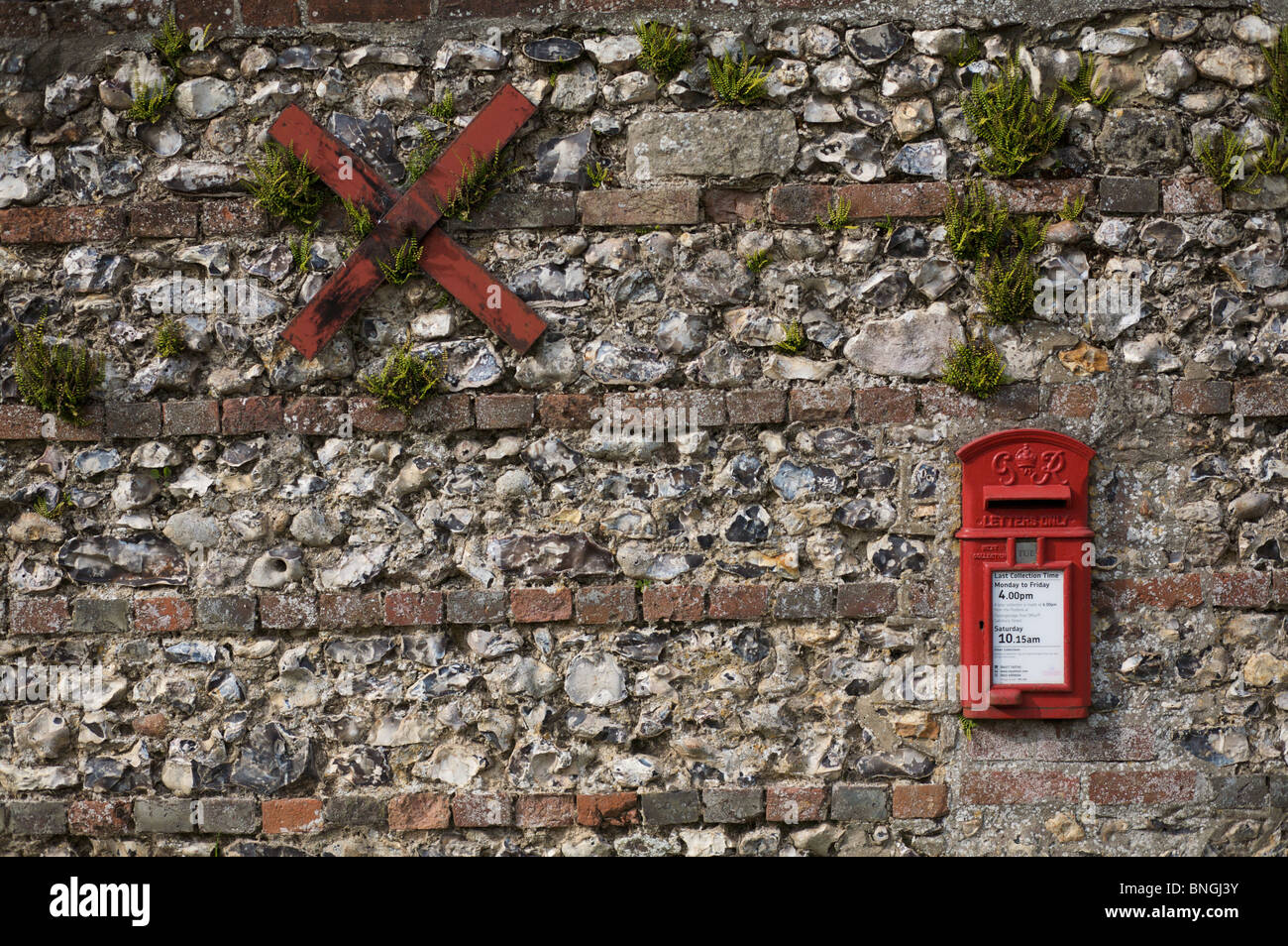 Eine traditionelle englische Feuerstein und Ziegel Wand mit seinen Briefkasten und x-förmigen Wandbewehrung. Stockfoto