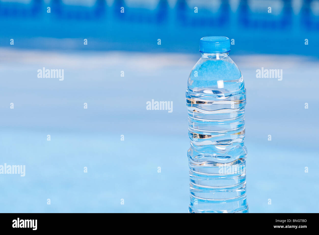 Schuss eine Flaschenwasser neben dem Pool Stockfoto