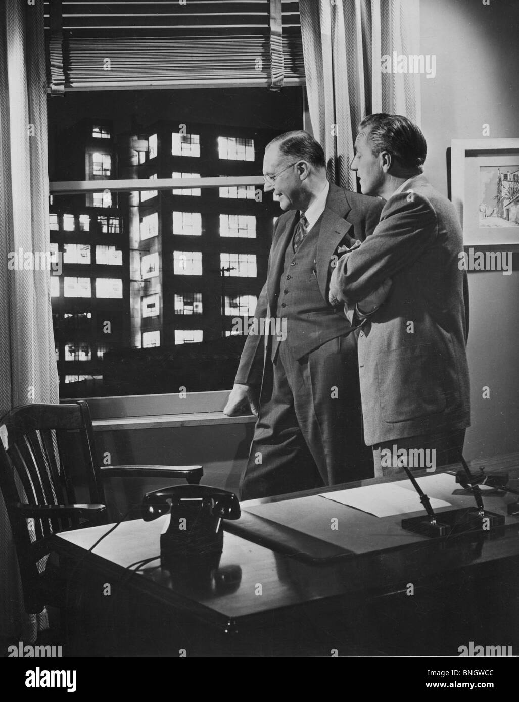 Zwei Geschäftsleute in Büro Blick durch Fenster, 1950er Jahre Stockfoto