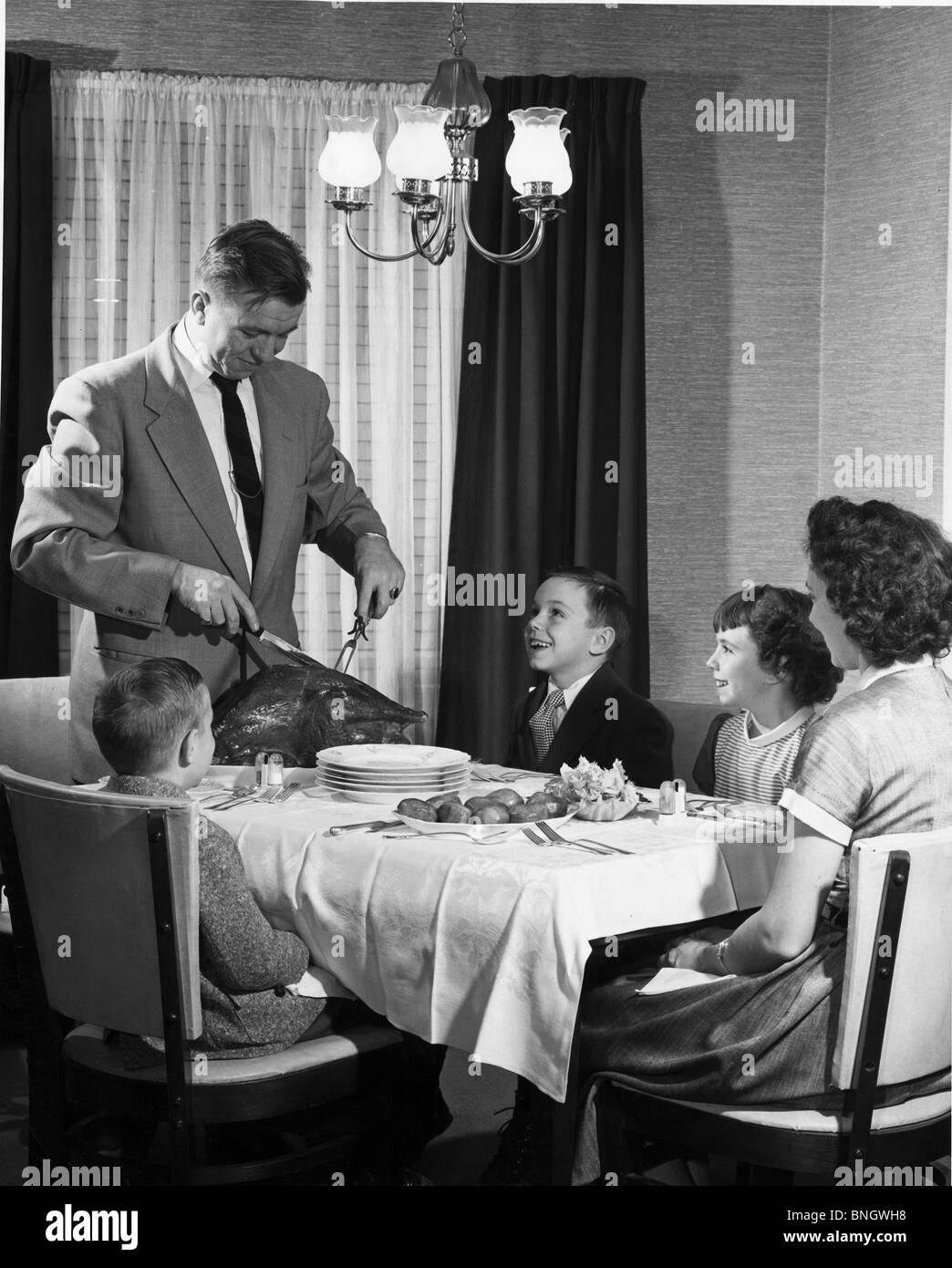 Älteres Paar mit ihren Kindern am Esstisch am Thanksgiving Day, Stockfoto