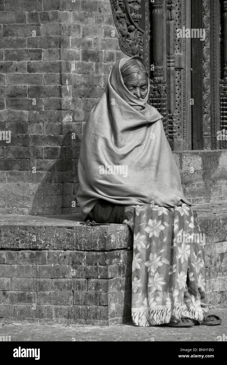 Alte Frau ruht in Bhaktapur Square, Nepal Stockfoto