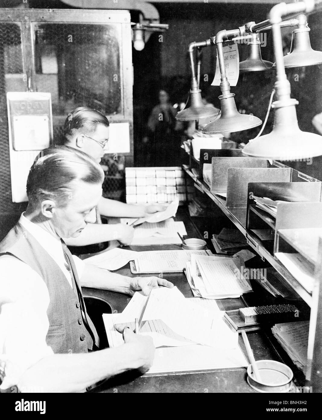 Seitenansicht der zwei männlichen Arbeitnehmer schneiden Papiere in einem Büro, New York City, USA Stockfoto