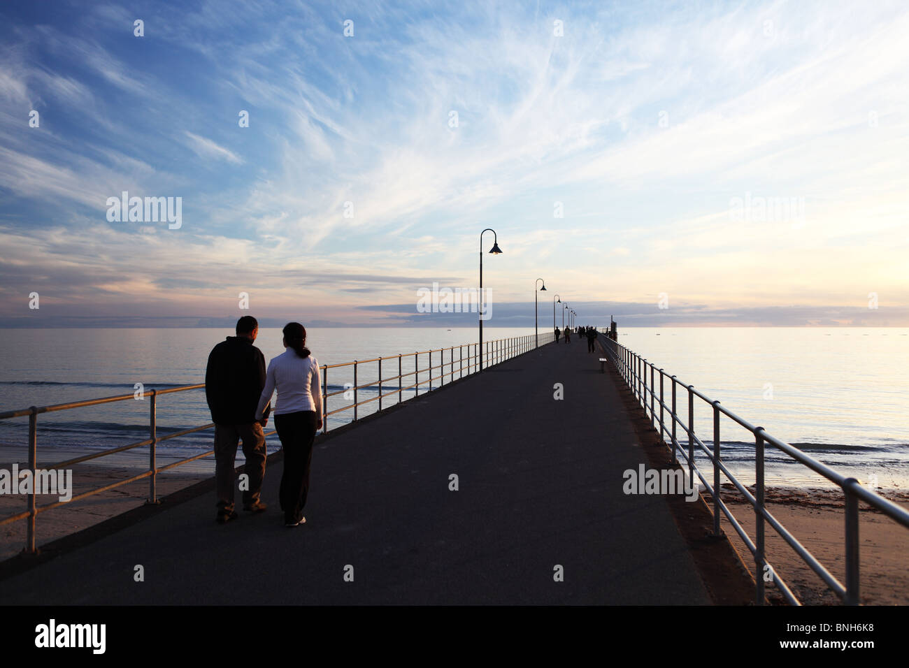 Menschen gehen auf der Mole von Glenelg in Glenelg, South Australia, Adelaide Stockfoto