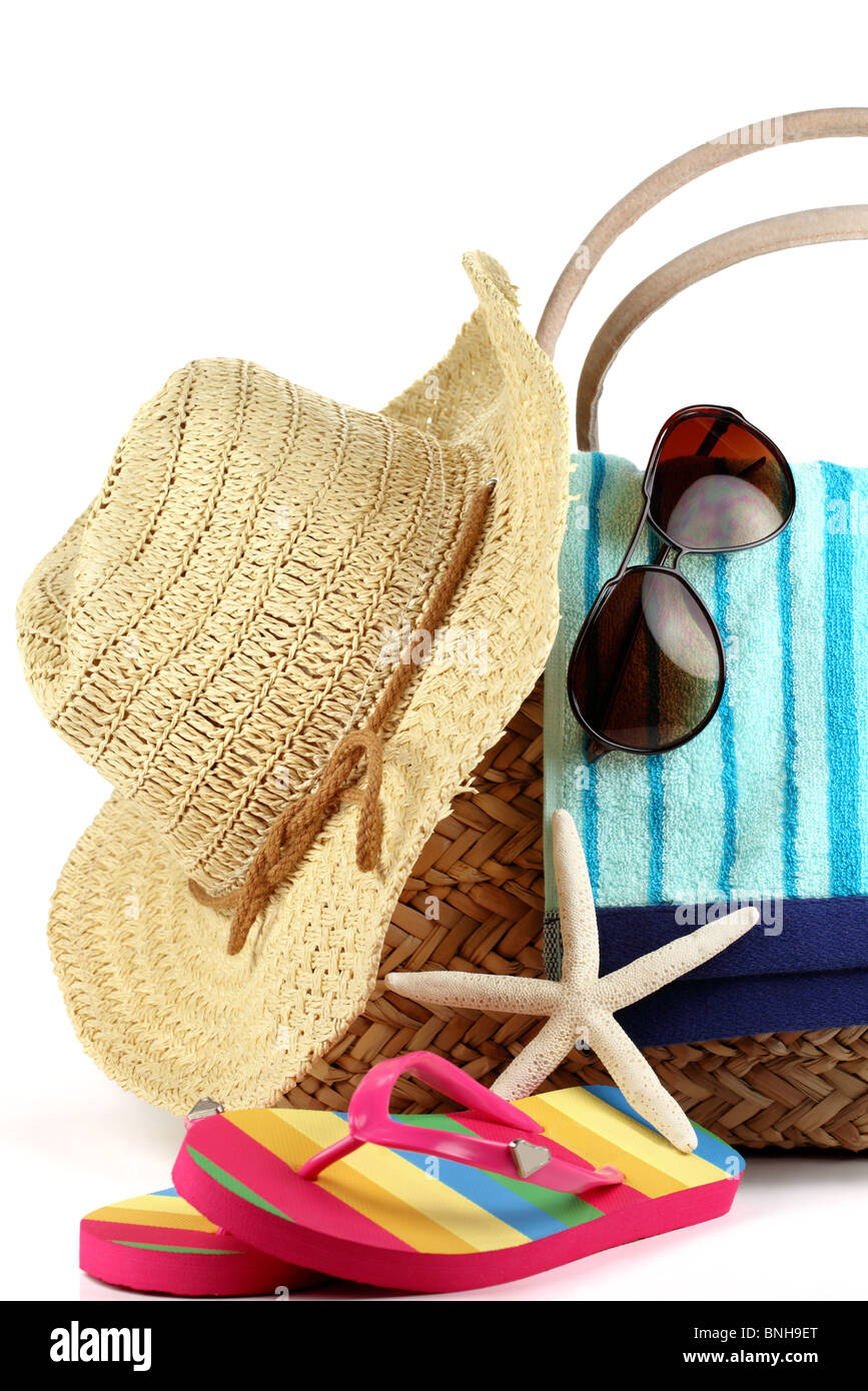 Strandtasche mit Handtuch, Stroh-Hut, Sonnenbrille und Flip Flops Stockfoto