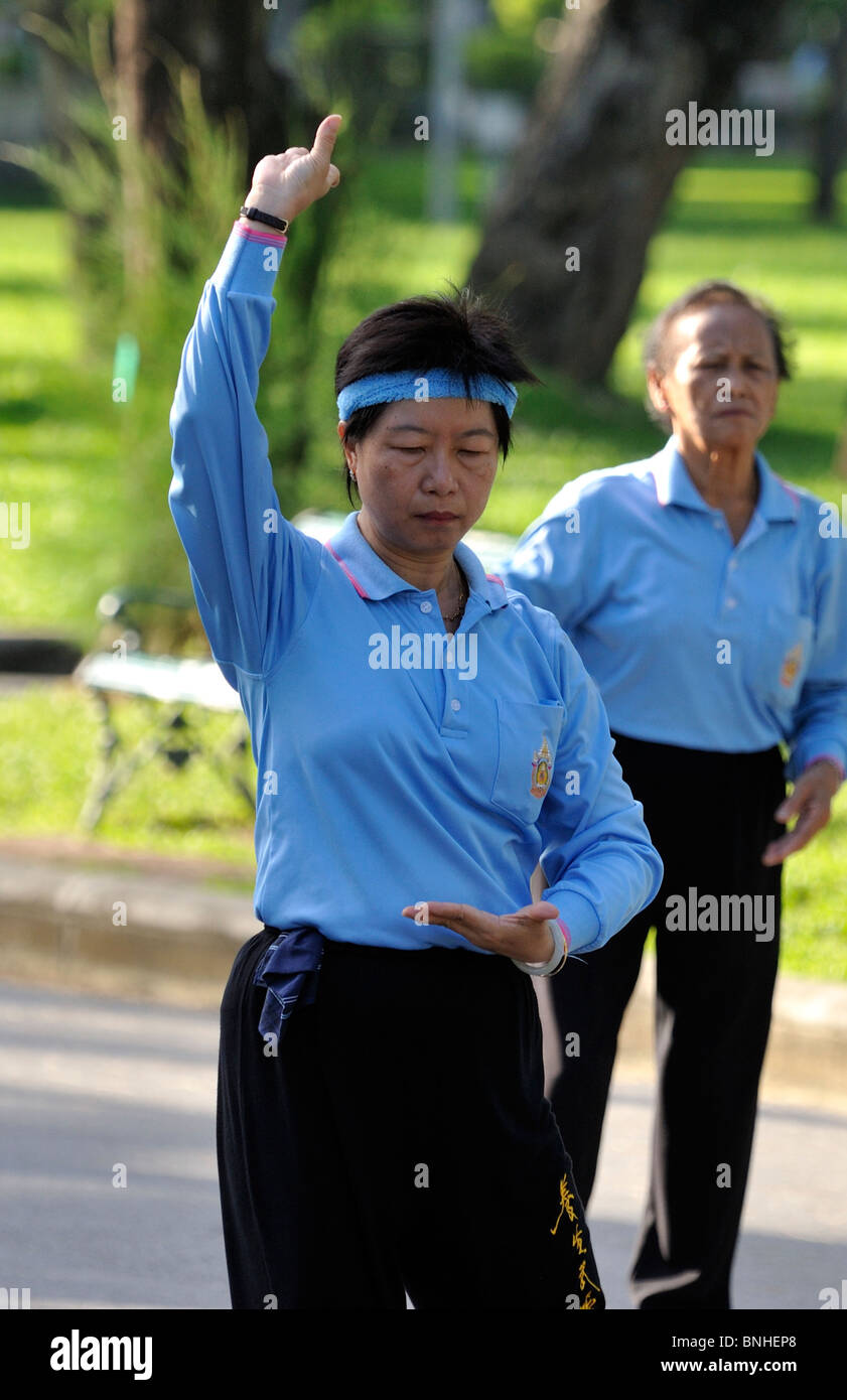 Frau an der Spitze einer Tai Chi Gruppe im Lumpini Park, Bangkok Stockfoto