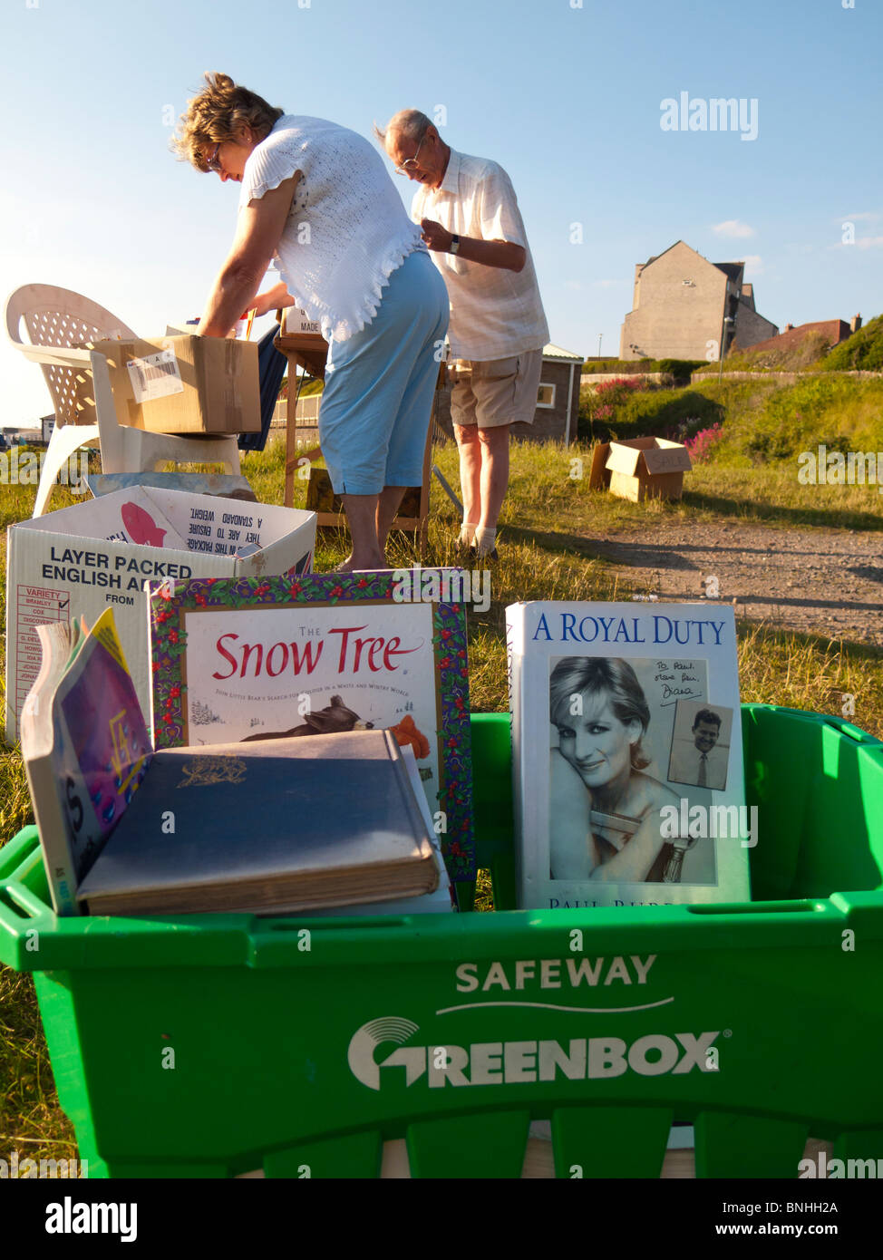 zwei Menschen Surfen aus zweiter hand zum Verkauf in einem Straßenrand "Ehrlichkeit" stall Flohmarkt, Aberystwyth UK Stockfoto