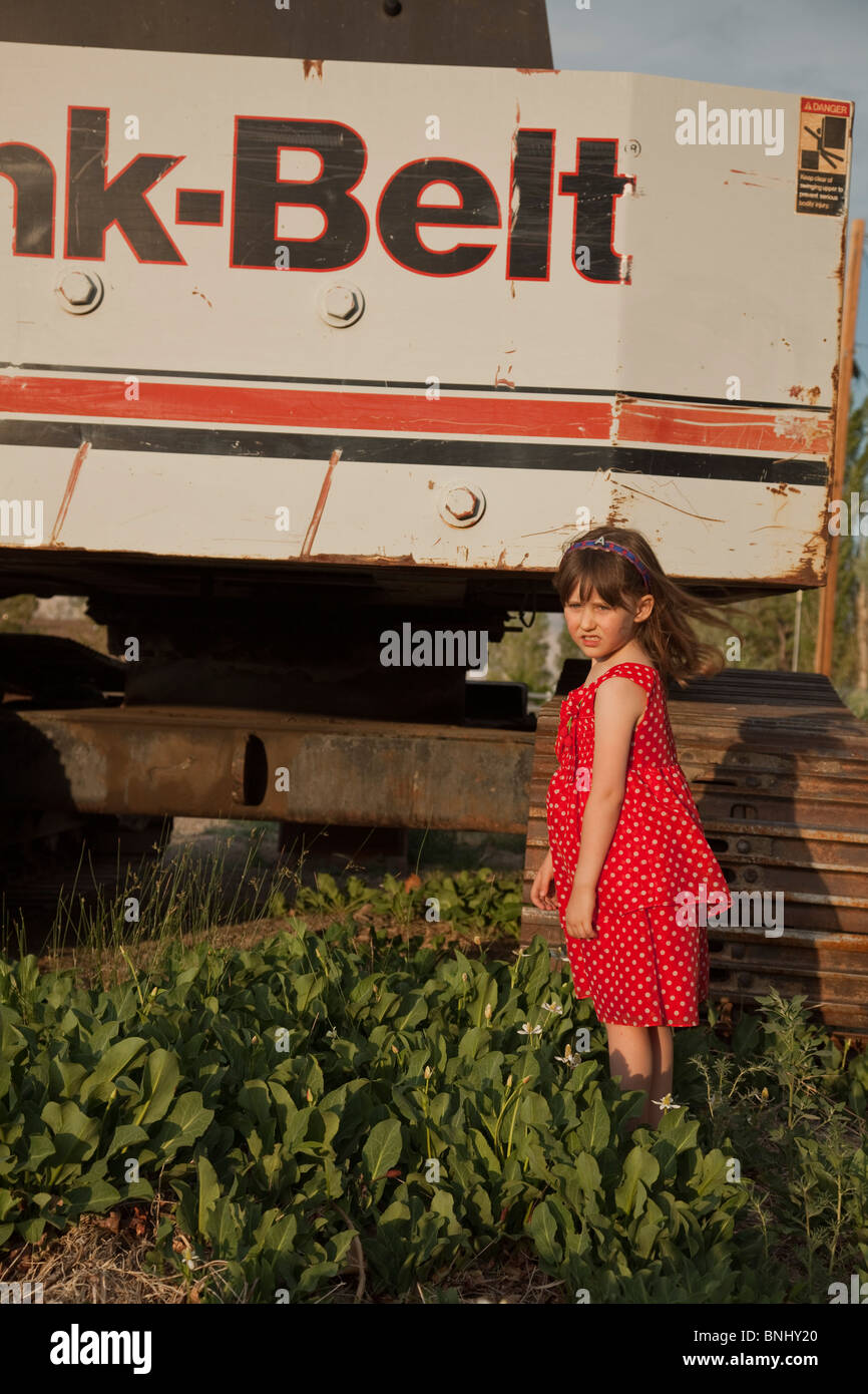 Mädchen in rot gepunkteten Kleid von Maschinen. Stockfoto