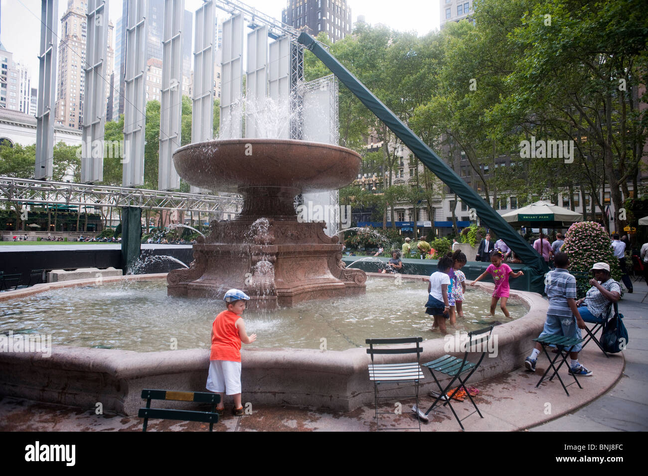 Kinder erfrischen Sie sich in der Hitzewelle dieses Sommers in Josephine Shaw Lowell Memorial Fountain im Bryant Park in New York Stockfoto