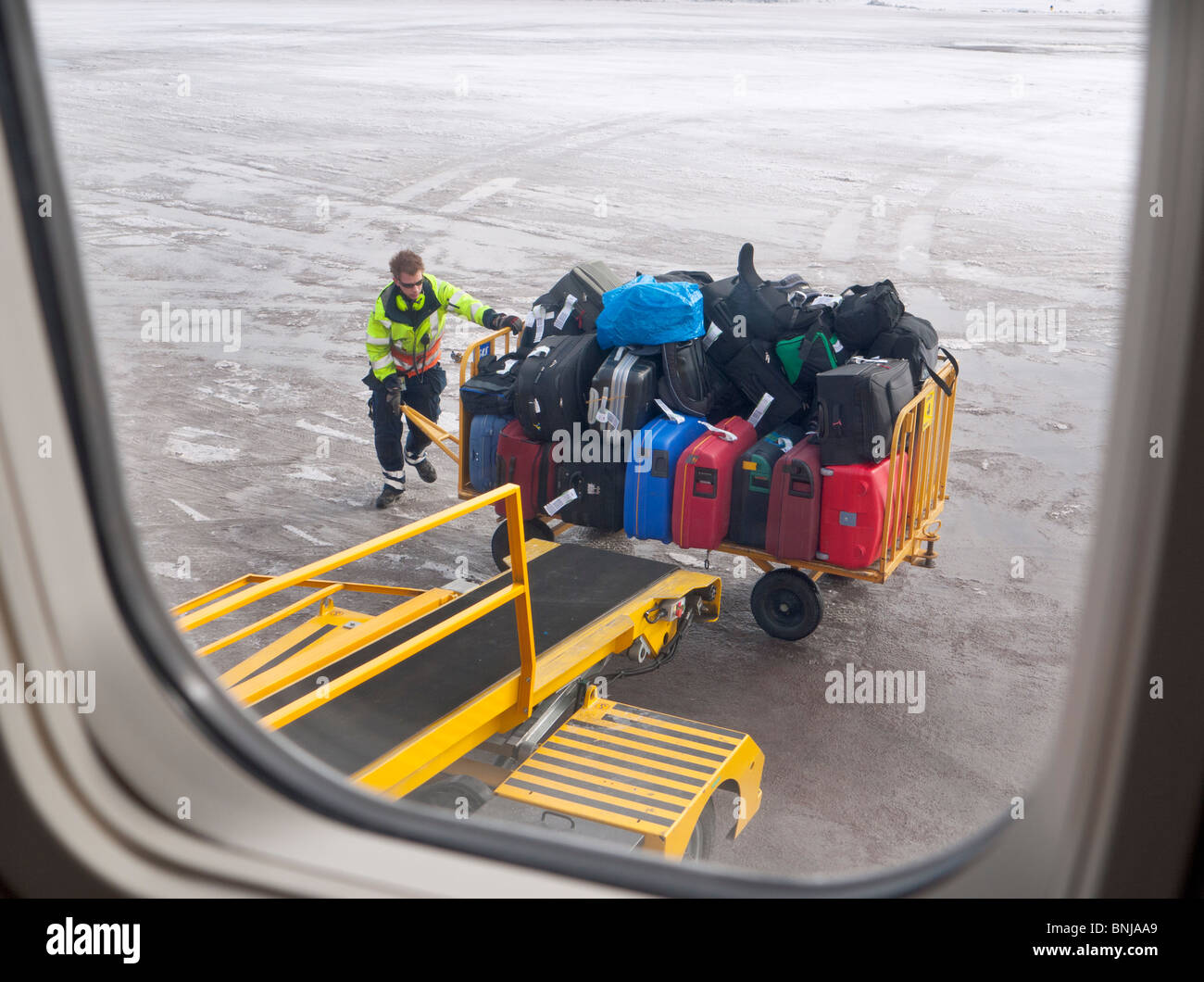 Ein Flughafenmitarbeiter lädt die Passagiere Fälle in ein Flugzeug am Flughafen Kiruna. Stockfoto