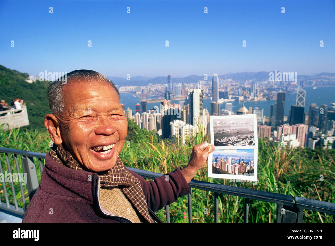 Asien China Hong Kong Souvenir Anbieter Postkarte Postkarten Mann männlich Skyline Stadtbild Wolkenkratzer modernen Gebäude der Stadt Victoria Stockfoto
