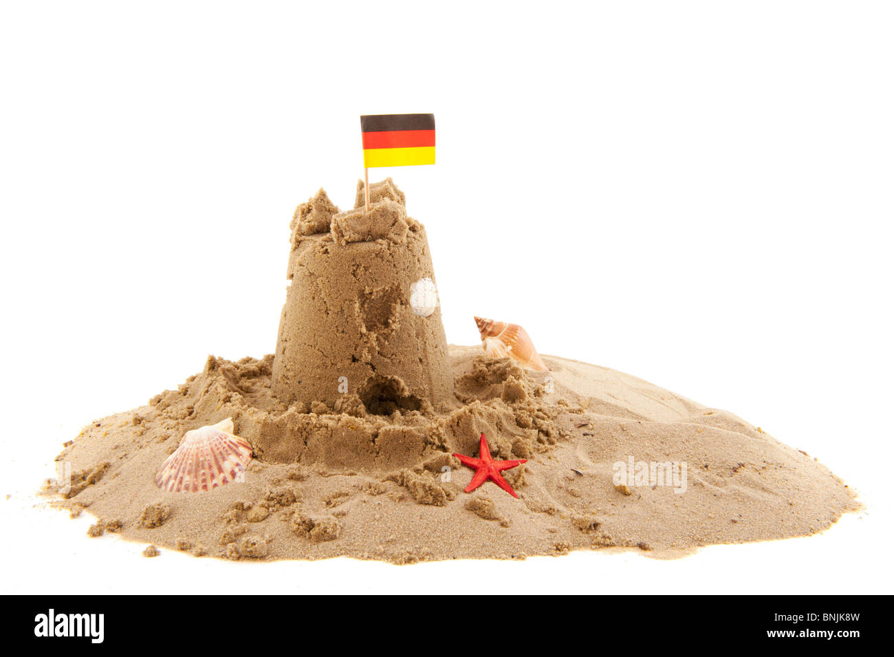 Sandburg mit deutscher Flagge isoliert auf weiß Stockfoto
