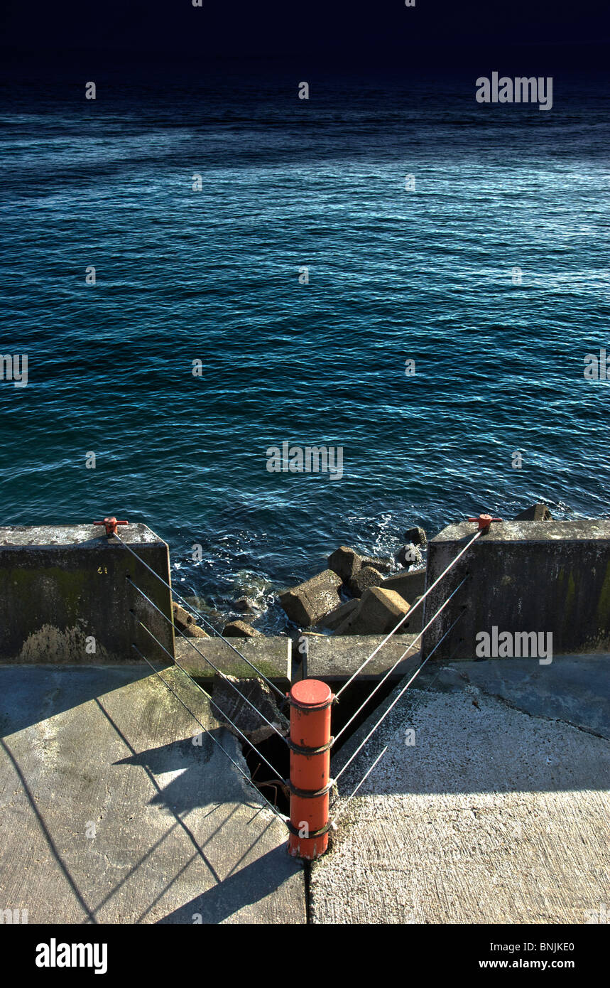 Hafenmauer und ruhige See Stockfoto