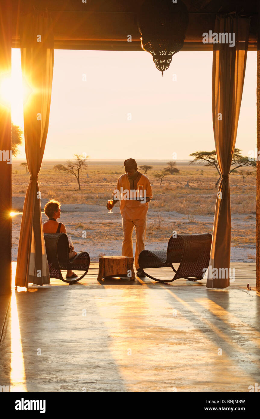 Sundowner Sonnenuntergang Drink serviert deck The Fort Fisher Pan Onguma Safari Camp Etosha National Park Kunene Region Namibia Afrika Stockfoto