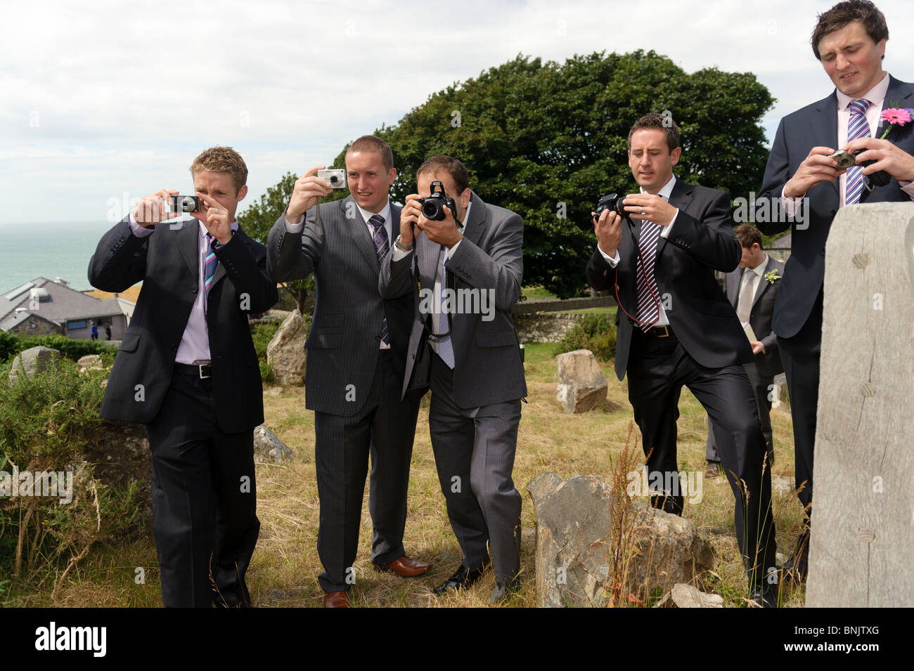Fünf Männer tragen Anzüge Gäste Hochzeit fotografieren auf ihren digitalen  Kameras, UK Stockfotografie - Alamy