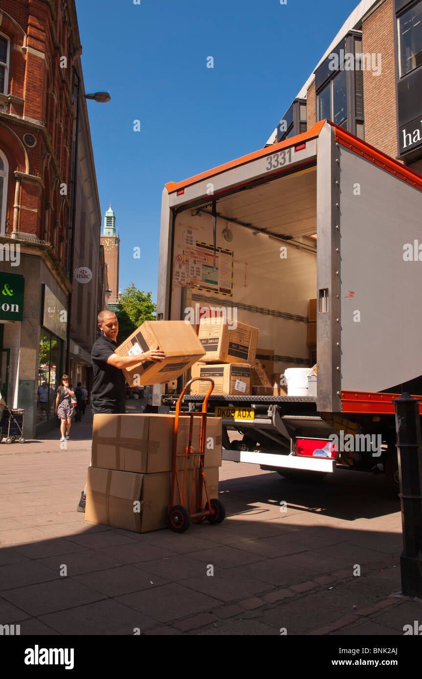 Ein Arbeiter packt Pakete von der Rückseite des TNT Kurier van LKW Fahrzeug in Norwich, Norfolk, England, Großbritannien, Uk Stockfoto