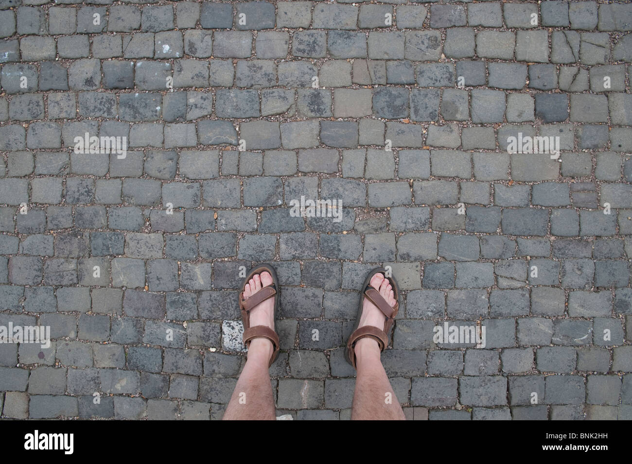 EET in Sandalen auf einer gepflasterten Straße Stockfoto
