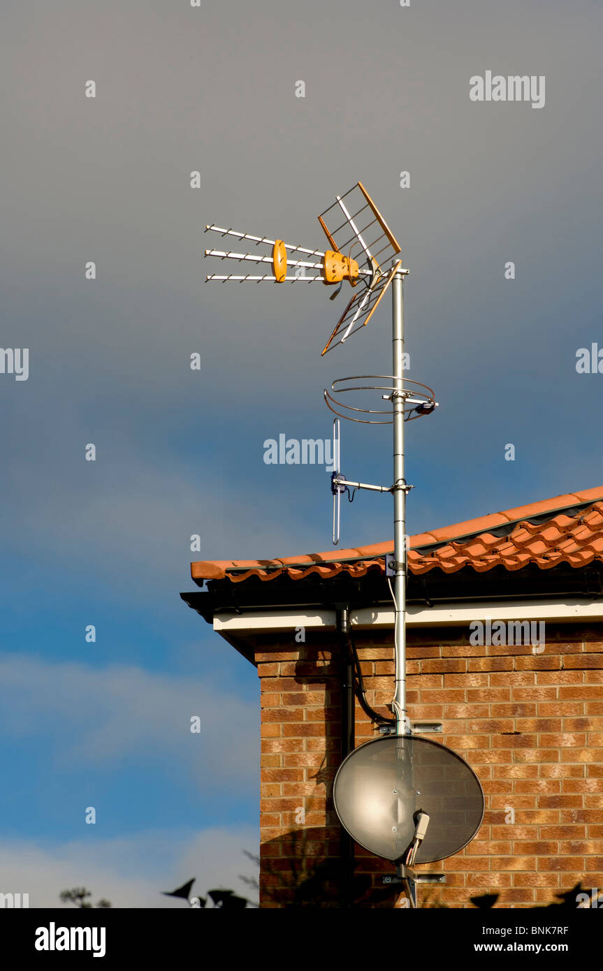 TV Antenne und Satellitenschüssel auf dem Dach eines Wohnblocks. Stockfoto