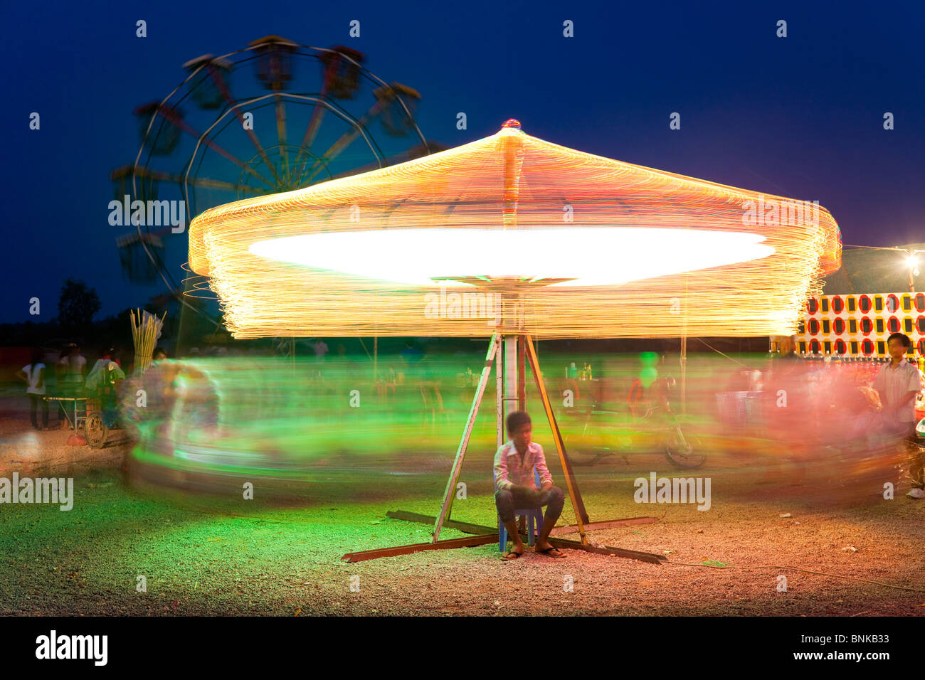 Langzeitbelichtung auf einen Rummelplatz mit Riesenrad im Hintergrund - Siem Reap, Kambodscha Stockfoto