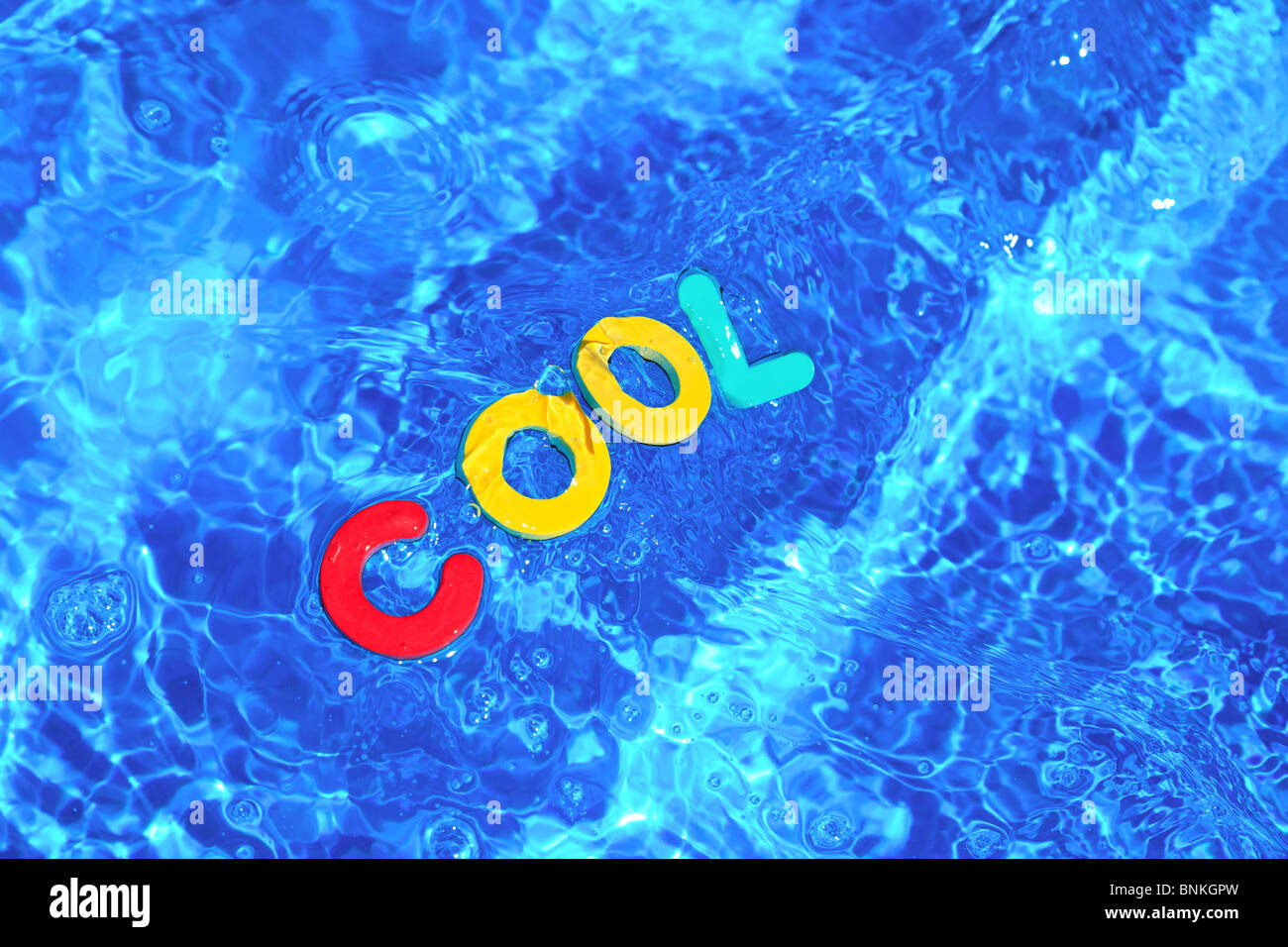 Das Wort COOL aus Schaum Buchstaben schwimmt auf der Wasseroberfläche eines Schwimmbades hergestellt Stockfoto