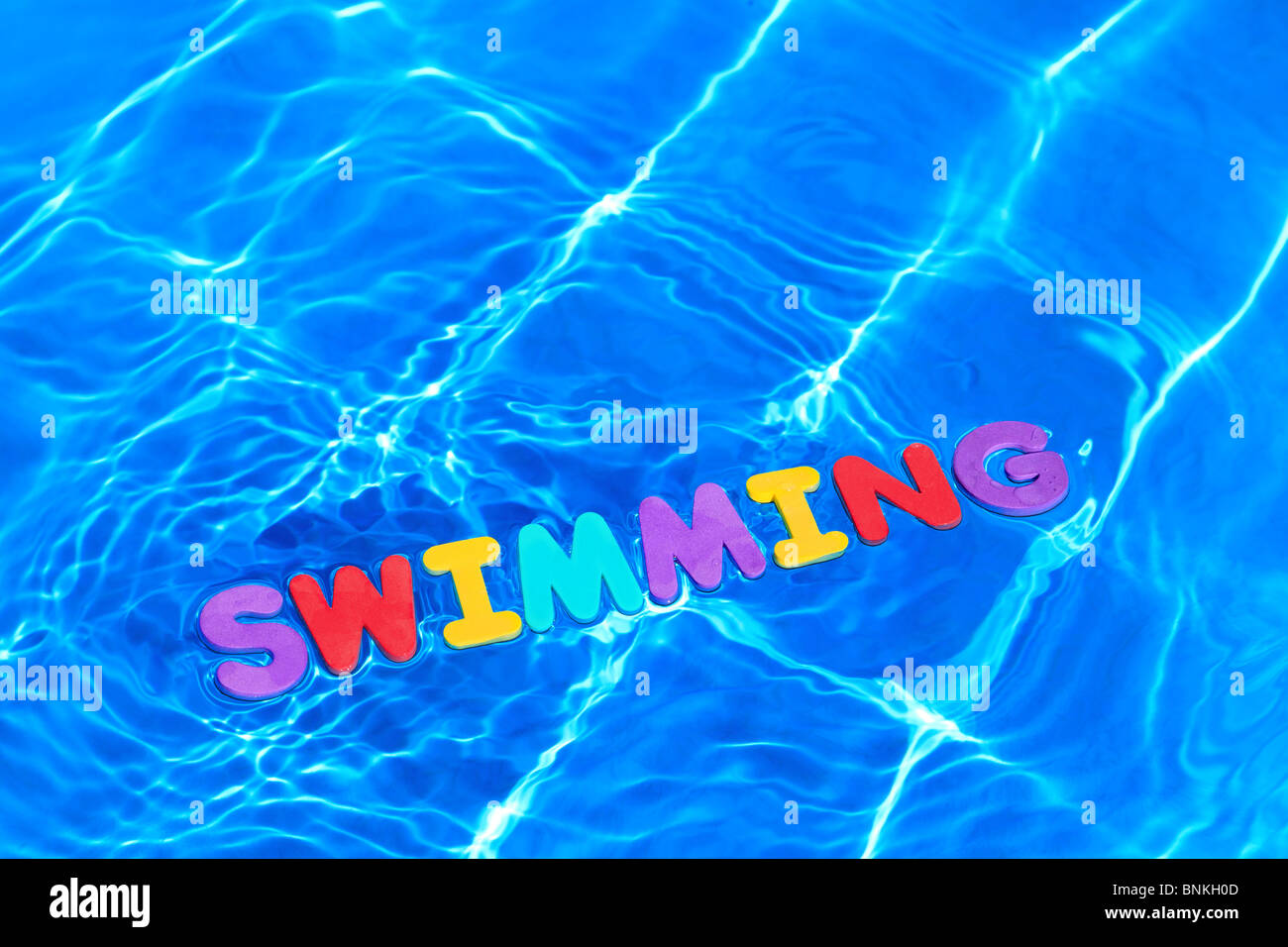 Das Wort wurde Schwimmen aus Schaum schwimmt auf der Wasseroberfläche eines Pools Stockfoto
