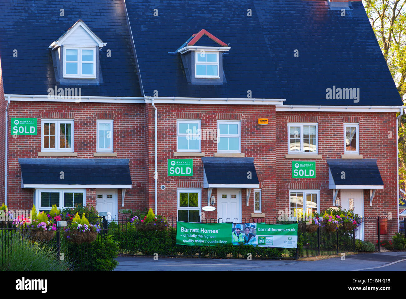 Reihe von neuen Barratt Häuser auf einer Wohnsiedlung in Hampshire, Südostengland, jeweils mit einem verkauften Schild an der Wand. Stockfoto