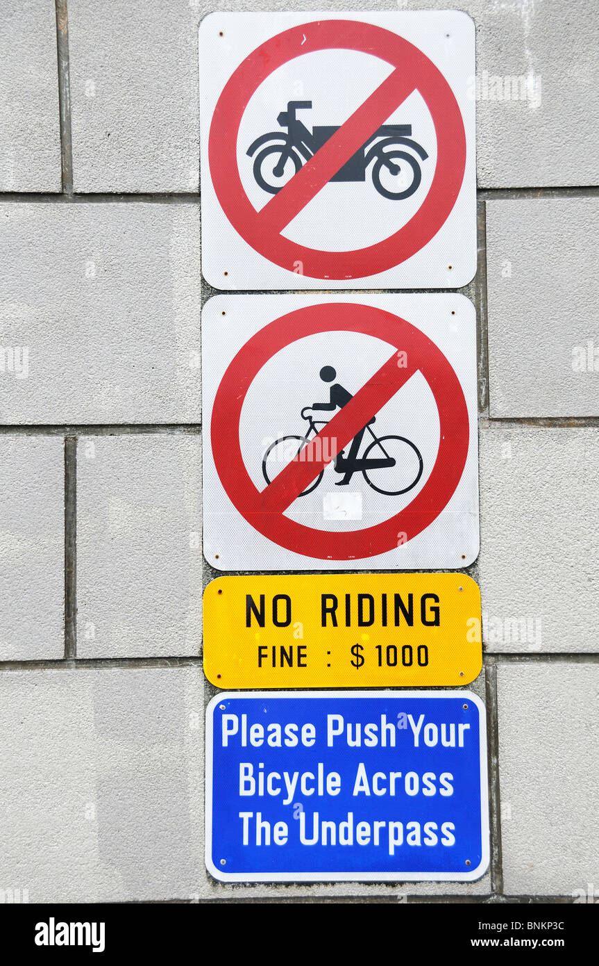 Verbotszeichen für Nichtraucher und kein Fahrrad fahren unter einer Brücke in Singapur Stockfoto