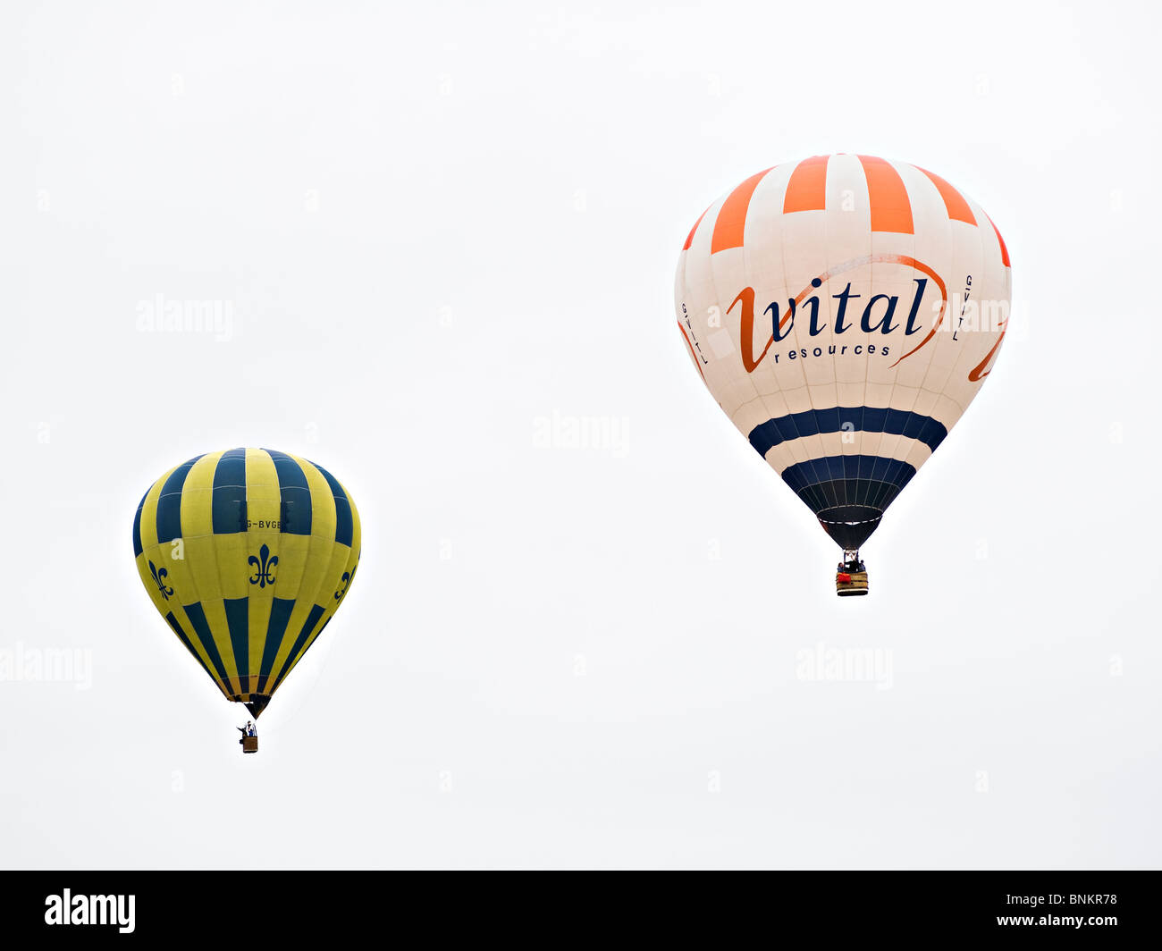 Zwei Heißluftballons, die kämpfen, um Höhe zu gewinnen über Alsager Cheshire England Vereinigtes Königreich UK Stockfoto