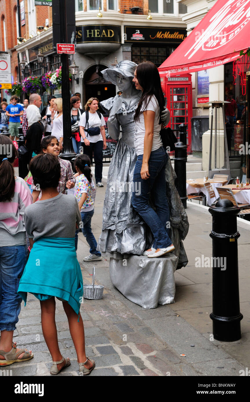 Straßenkünstler menschliche Statue stellt mit einem Touristen für ein Foto, Covent Garden, London, England, UK Stockfoto