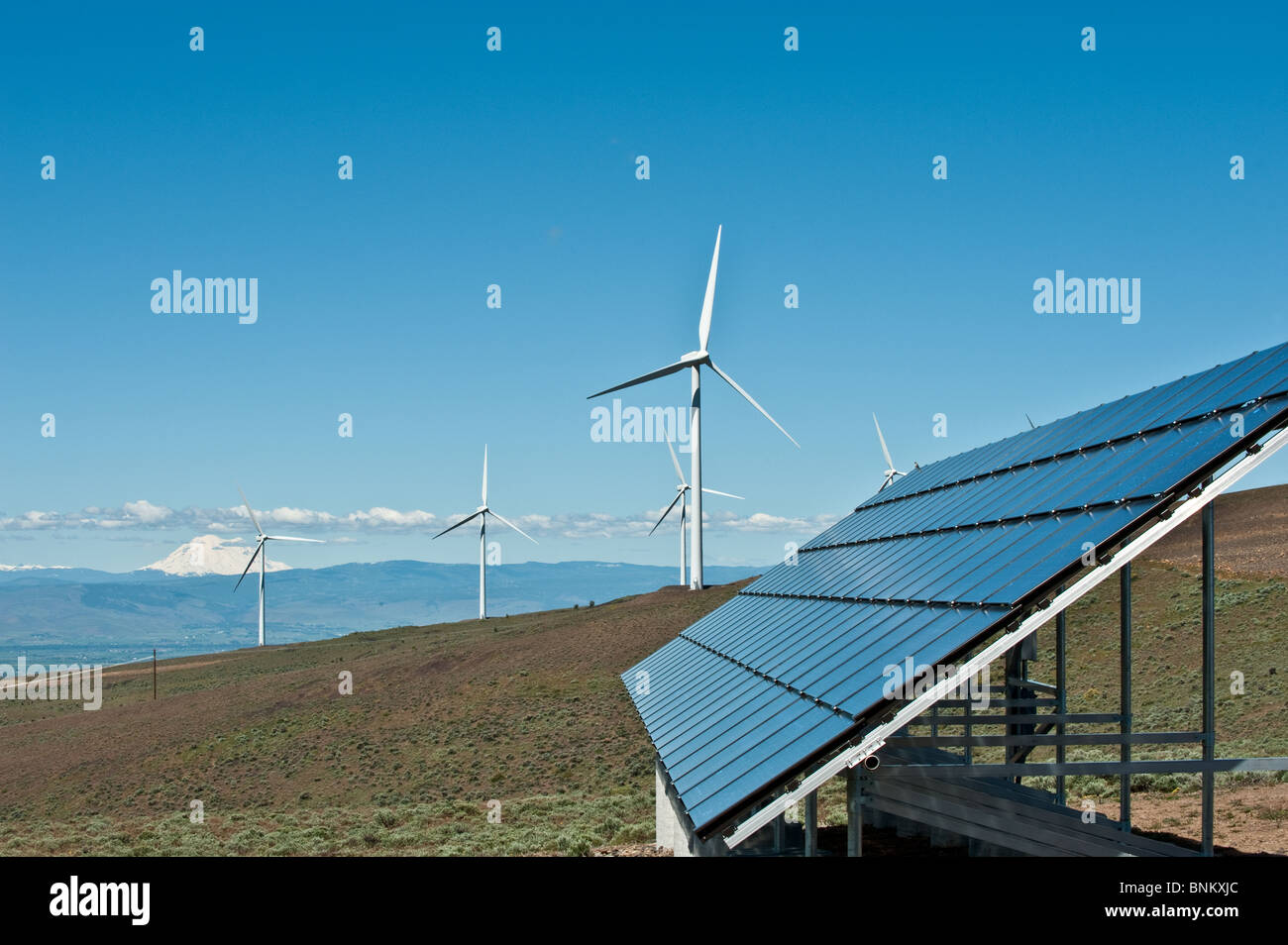 Riesigen Windkraftanlagen und Solarstrom-Panel auf einem Bergrücken Stockfoto