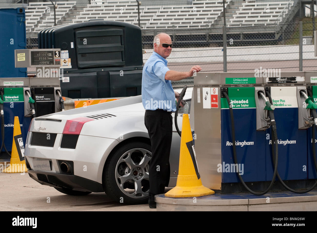 Ein Mann seinen Lamborghini-Supersportwagen mit Kraftstoff auffüllen Stockfoto