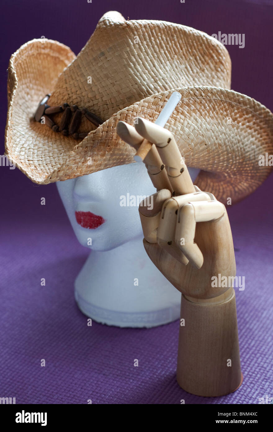 Schaufensterpuppe Kopf mit Cowboy-Hut und hölzerne Hand mit Zigarette-Ausschnitt Stockfoto