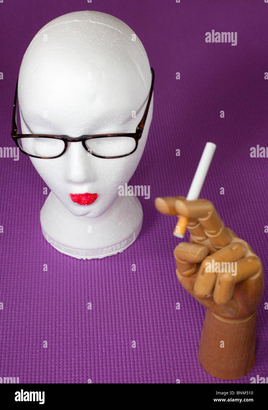 Schaufensterpuppe Kopf und hölzerne Hand mit Zigarette-Ausschnitt Ausschnitt Stockfoto