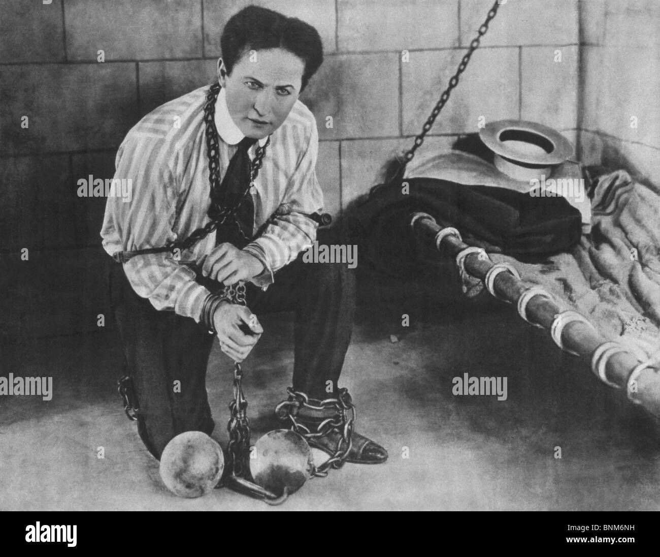 Promo-Foto c1898 Magier + Entfesselungskünstler Harry Houdini (1874-1926) zurückgehalten in Ketten und in eine Zelle gesperrt. Stockfoto