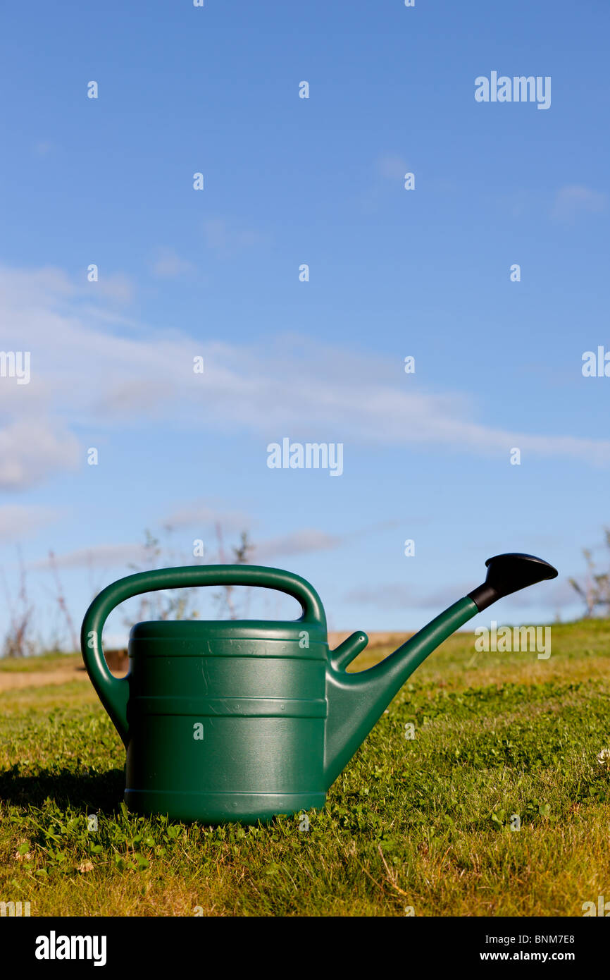 Eine grüne Kunststoff-Gießkanne im Garten Stockfoto