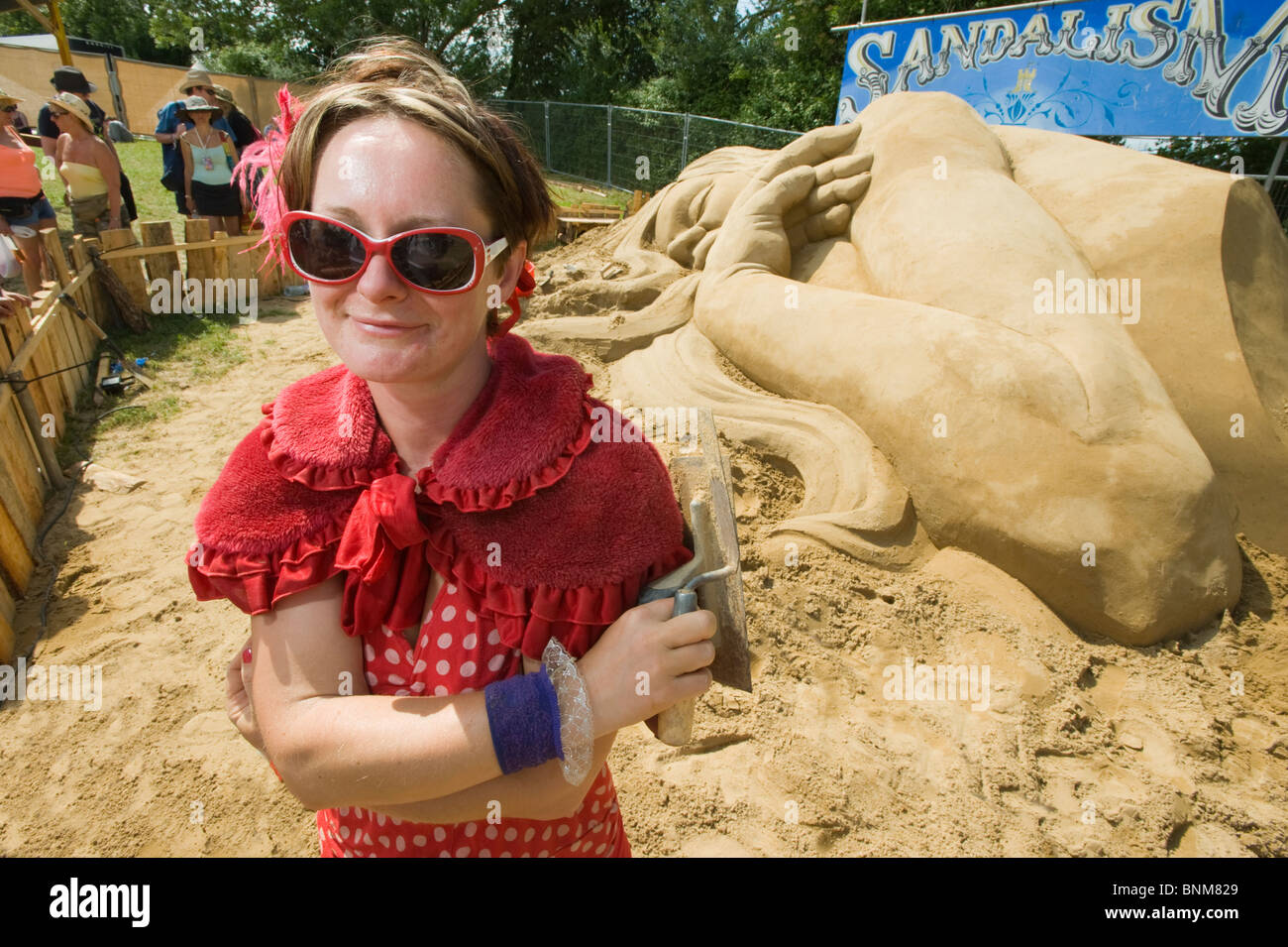 Zara-Blick, der "Sandalism" stand vor ihr Sandskulpturen in der Parkanlage des Glastonbury Festivals, England. Stockfoto