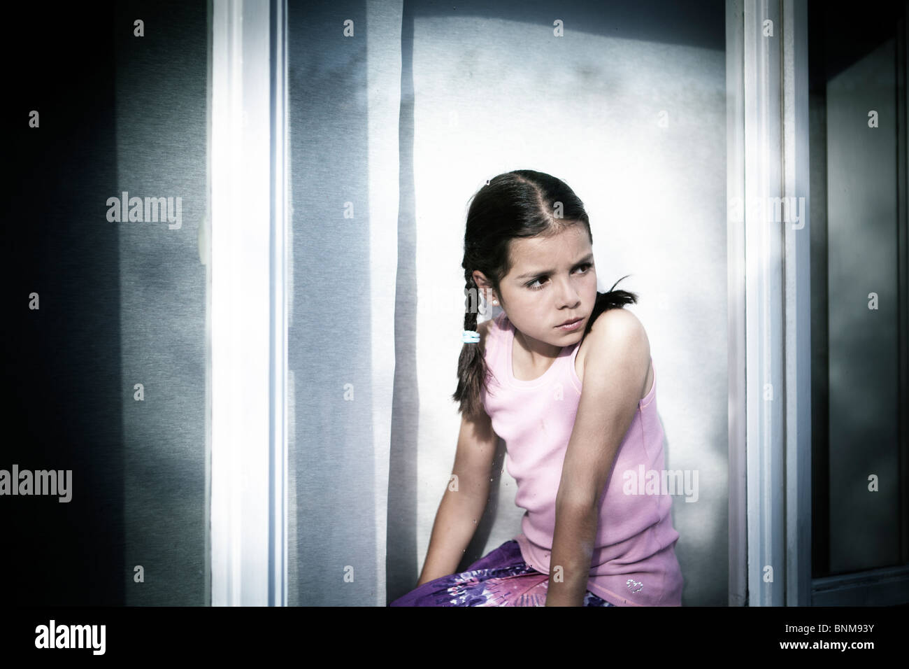 Mädchen auf der Suche durch Fenster Stockfoto