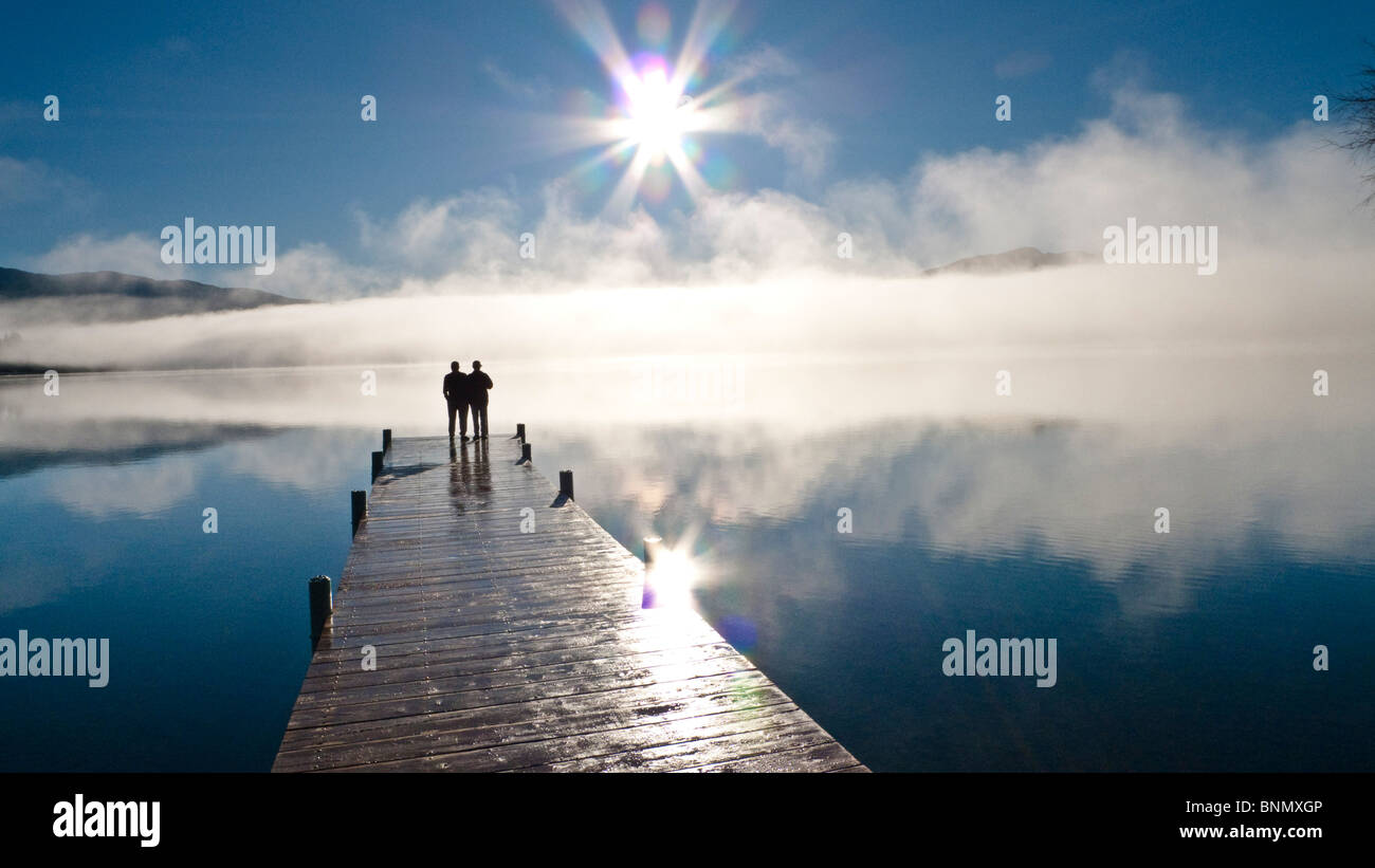 Paar steht auf einem Dock und Silhouette gegen den Nebel heben aus Whatcom See im Winter, Bellingham, Washington, USA Stockfoto