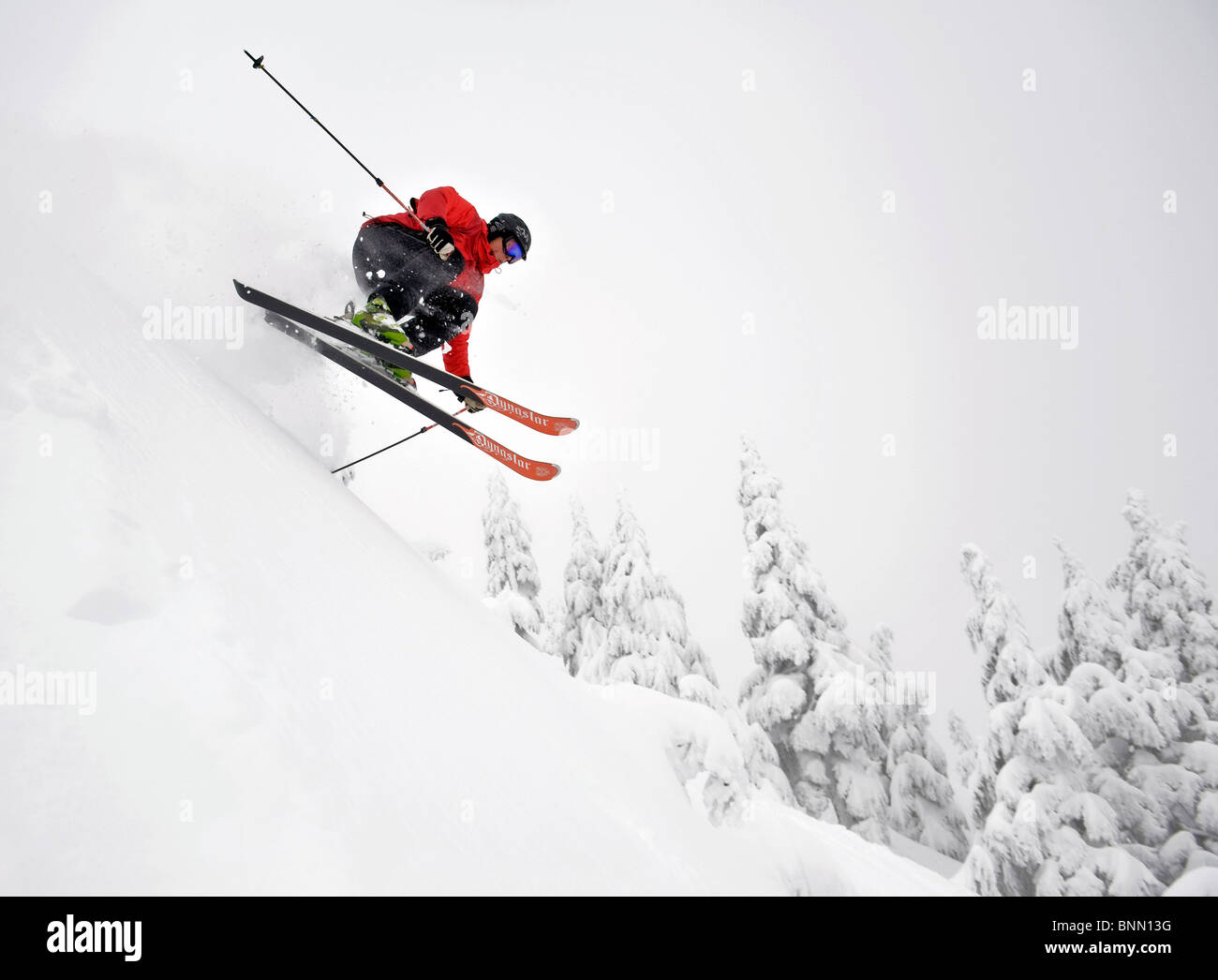 Ein Skifahrer wird ein wenig Luft beim Skifahren bergab im Eaglecrest Skigebiet in Juneau, Alaska Stockfoto